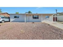 Charming single-story home featuring a low-maintenance front yard with rock landscaping and a covered entry at 2823 W Banff Ln, Phoenix, AZ 85053