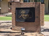 Welcoming brick sign for The Mews On Tenth Place community near sidewalk and landscaped lawn at 5035 N 10Th Pl # 109, Phoenix, AZ 85014
