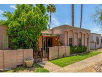 Charming home featuring stucco walls, decorative arches, and a lush front yard with mature trees at 509 N Hobson Plz, Mesa, AZ 85203