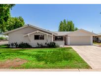 Charming single-story home featuring a well-maintained lawn, fresh paint, and attached garage at 556 S Forest --, Mesa, AZ 85204