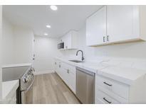 Bright kitchen featuring white cabinets, stainless steel appliances, and quartz countertops at 948 S Alma School Rd # 1, Mesa, AZ 85210