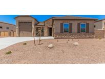 Charming single-story home with stone accents, desert landscaping, and a spacious three-car garage at 17308 W Royal Palm Rd, Waddell, AZ 85355