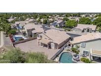 Aerial view of a tan home showing the pool and covered patio of this well manicured lot at 22019 N 59Th Dr, Glendale, AZ 85310