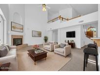 Bright living room boasts high ceilings, a fireplace, and ample seating for entertaining at 22019 N 59Th Dr, Glendale, AZ 85310