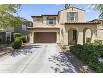 Charming two-story home with arched entryway, brown garage door, and well-maintained landscaping at 2213 N Park Meadows Dr, Buckeye, AZ 85396