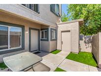 Charming townhome entrance with a small yard, featuring a table and updated neutral paint at 2311 E Hartford Ave # 29, Phoenix, AZ 85022