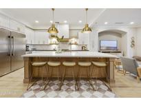 Stunning kitchen with white cabinetry, a large island with seating, and pendant lighting fixtures at 2501 S Roanoke St, Gilbert, AZ 85295