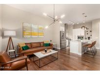 Bright living room with a modern light fixture, hardwood floors, and an open layout to the kitchen at 3131 N Central Ave # 3004, Phoenix, AZ 85012