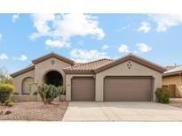 Charming single-story home with a tile roof, three-car garage, and desert landscaping at 40614 N Harbour Town Ct, Anthem, AZ 85086