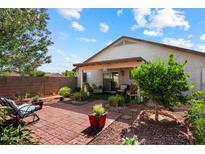Secluded backyard oasis with brick-paved patio, lush greenery, and comfortable seating areas at 481 S San Marcos Dr, Apache Junction, AZ 85120