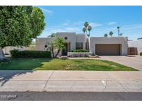 Stylish modern home with a desert landscaped front yard and a two-car garage with palm trees at 6707 E Beverly Ln, Scottsdale, AZ 85254