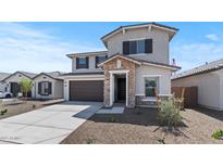 Charming two-story home featuring a stone-accented entrance, dark shutters, and a well-maintained front yard at 7327 S 76Th Ln, Laveen, AZ 85339