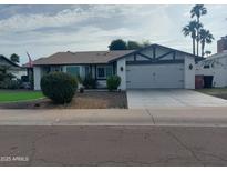 Charming single-story home featuring a well-maintained front yard, attached garage, and inviting curb appeal at 8879 E Friess Dr, Scottsdale, AZ 85260