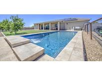 Inviting backyard oasis with refreshing pool, waterfall feature, and ample space for outdoor entertaining at 9759 E Brown Rd, Mesa, AZ 85207