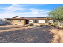 Charming single-story home featuring brick and stucco exterior, complemented by a desert-style landscaped front yard at 1044 E Irvine Rd, Phoenix, AZ 85086
