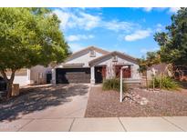 Charming single-story home with a well-manicured front yard and a two car garage at 1432 E Penny Ln, San Tan Valley, AZ 85140