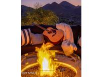Inviting outdoor space featuring a cozy firepit, sofa, guitar, and scenic mountain views, perfect for relaxation and entertainment at 15054 E Sundown Dr, Fountain Hills, AZ 85268