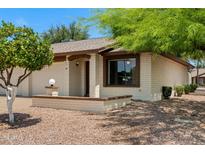 Charming single-story home featuring a cozy front porch with a brick accent wall and well-maintained landscaping at 2064 S Farnsworth Dr # 43, Mesa, AZ 85209