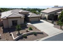A charming home boasting a desert landscape, neutral colors, and a spacious three-car driveway at 2122 N Stapley Dr, Mesa, AZ 85203