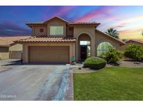Charming two-story home featuring a well-manicured lawn, a two car garage and a terra cotta roof at 2340 W Myrtle Dr, Chandler, AZ 85248