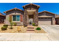 Charming single-story home with stone accents, desert landscaping, and covered entryway at 24013 N 165Th Ave, Surprise, AZ 85387