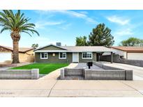 Charming single-story home with a well-manicured lawn and a classic desert landscape in a sunny, residential neighborhood at 3825 E Captain Dreyfus Ave, Phoenix, AZ 85032