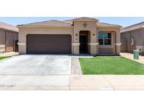 Charming single-story home featuring a desert landscape, brown garage door, and tiled roof at 41903 W Rojo St, Maricopa, AZ 85138
