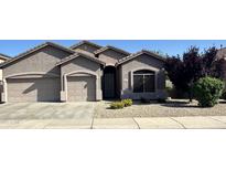 Charming single-story home with desert landscaping, a two-car garage, and a welcoming entryway at 7227 W Paradise Ln, Peoria, AZ 85382