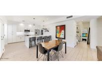 Modern kitchen features white cabinets, stainless steel appliances, and a large island with bar seating at 9028 E Altadena Ave, Scottsdale, AZ 85260