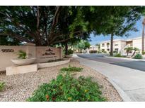 Inviting view of the Mira Vista Luxury Condominium Homes complex entrance with beautiful landscaping and mature trees at 9550 E Thunderbird Rd # 152, Scottsdale, AZ 85260