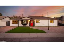 Charming single-story home showcasing a red front door, manicured lawn, and updated curb appeal at 1027 S Siesta Ln, Tempe, AZ 85281
