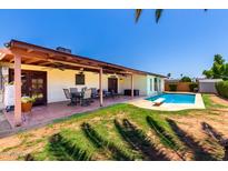 Inviting backyard showcases covered patio, dining set, grassy area, and refreshing private pool at 10820 N 45Th Dr, Glendale, AZ 85304