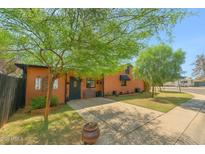 Charming home with a comfortable bench, landscaping, and an inviting driveway at 2020 W Marshall Ave, Phoenix, AZ 85015