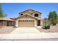Two-story tan home with a two car garage and desert landscaping at 2210 E Paraiso Dr, Phoenix, AZ 85024
