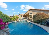 Inviting backyard pool with desert landscaping and a charming rock waterfall feature at 2432 W Oberlin Way, Phoenix, AZ 85085