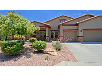Charming home exterior boasting desert landscaping, a two-car garage and covered front porch at 4609 W Challenger Trl, New River, AZ 85087