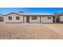Charming single-story home with fresh white paint, gravel landscaping, and inviting covered entryway at 6140 W Berkeley Rd, Phoenix, AZ 85035