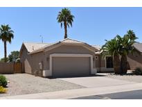 Charming single-story home featuring a two-car garage and desert landscaping with palm trees at 6460 S Springs Pl, Chandler, AZ 85249