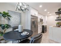 Eat-in kitchen featuring stainless steel appliances, quartz counters, and a modern light fixture at 1005 N Granite Reef Rd, Scottsdale, AZ 85257