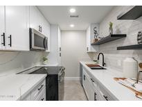 Bright and airy kitchen with white cabinets and stainless steel appliances at 1005 N Granite Reef Rd, Scottsdale, AZ 85257