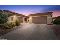 Charming home featuring a three-car garage, desert landscaping, and a welcoming red front door at 42726 N Livingstone Way, Anthem, AZ 85086