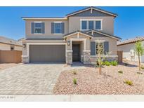 Charming two-story home with neutral paint, grey trim and a grey two car garage in a desert landscaped front yard at 5023 W Hardtack Trl, Laveen, AZ 85339