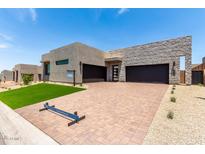 Modern home featuring stone accents, a brick driveway, and a well-manicured lawn at 5744 E Lowden Rd, Cave Creek, AZ 85331