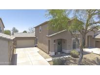 Inviting two-story home with a tile roof, a well-maintained lawn, a large tree, and an attached garage at 7227 E Northridge St, Mesa, AZ 85207