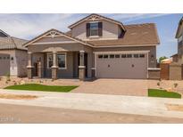 Attractive two-story home with a well-maintained lawn and a neutral color scheme at 15634 W Georgia Dr, Surprise, AZ 85379