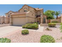 Charming two-story home featuring a two-car garage and beautifully landscaped front yard with desert rock and green bushes at 1606 N Apache Dr, Chandler, AZ 85244