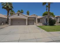 Inviting single-story home featuring a three-car garage, desert landscaping, and charming curb appeal at 1826 W Oriole Way, Chandler, AZ 85286