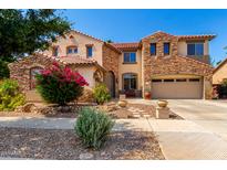Charming two-story home featuring stone accents, a red tile roof, and a well-manicured front yard at 18402 E Oak Hill Ln, Queen Creek, AZ 85142