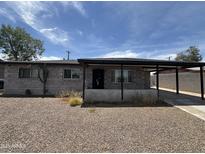 Single story home with a carport, gravel front yard, and block construction at 2007 W Roeser Rd, Phoenix, AZ 85041