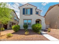 Charming two-story home featuring a light-colored facade, red tile roof, and blue shutters on the upper window at 2494 N Heritage St, Buckeye, AZ 85396
